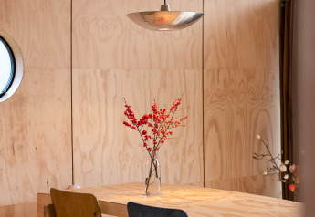 Sala da pranzo moderna con sedie colorate e interni in legno al Wrap house con sauna al Resort de Parel, Paesi Bassi.