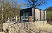 Modernes Tiny House am Kohnenhof in Luxemburg mit Holzverkleidung und Terrasse in ruhiger Natur.