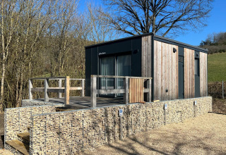 Tiny house moderna al Kohnenhof in Lussemburgo, rivestita in legno con terrazza immersa nella natura.