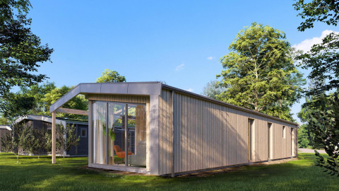 Udvendig billede af Cube Lodge 4, en moderne træhytte med store vinduer, omgivet af grønt landskab.