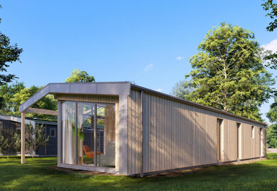 Udvendig billede af Cube Lodge 4, en moderne træhytte med store vinduer, omgivet af grønt landskab.