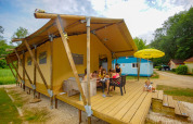 Familia disfruta de una comida al aire libre frente a una tienda safari Lodgetent Bordeaux en La Draille, Francia.