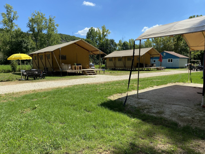 Safari tents Lodgetent Bordeaux at La Draille in France with outdoor seating and greenery on a sunny day.