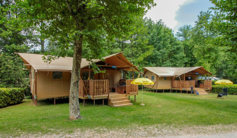 Tiendas safari en Lodgetent Brive, La Draille, Francia, rodeadas de árboles verdes y un entorno tranquilo.