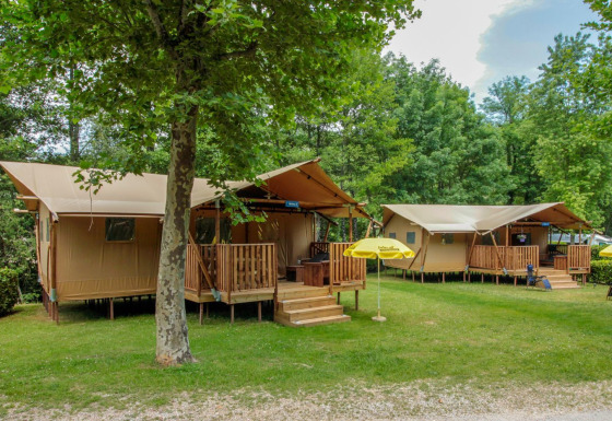 Tiendas safari en Lodgetent Brive, La Draille, Francia, rodeadas de árboles verdes y un entorno tranquilo.