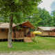 Safari-telte ved Lodgetent Brive på La Draille i Frankrig, omgivet af grønne træer og afslappende natur.