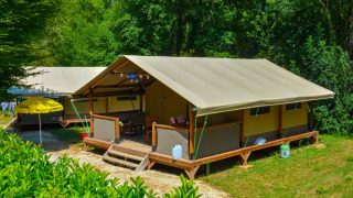 Safaritent Lodgetent Gourdon te La Draille in Frankrijk, midden in het groen en omgeven door bomen.