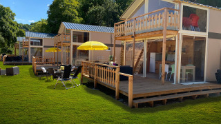 Luxe safaritent Belle Vue bij La Draille in Frankrijk met houten terras en buitenzitje op het gras.