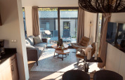 Modern and cozy lodge living area with large windows, comfortable seating, and view to the outdoor terrace.