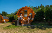 To personer slapper af foran en traktorcabin i Biggesee, Tyskland, under en klar blå himmel.