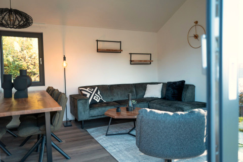 Modern living room at Hackfort lodge in Biggesee, Germany, featuring a cozy corner sofa and stylish décor.