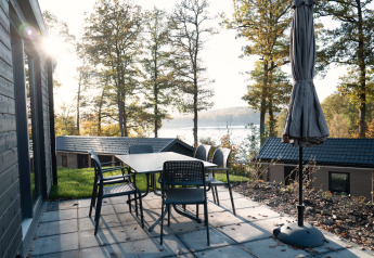 Terras met tafel en stoelen aan Hackfort Lodge met uitzicht op het meer bij Biggesee in Duitsland.