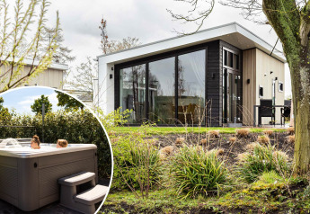 Nature Lodge Wellness (Spa) im Park Westerkogge, Niederlande, mit moderner Hütte und Whirlpool im Freien.