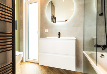 Modernes Badezimmer in der Waterhoeve Wellness (Whirlpool), Park Westerkogge, Niederlande mit rundem Spiegel.