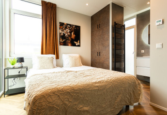 Modernes Schlafzimmer in der Waterhoeve Wellness (Hottub) Lodge im Park Westerkogge, Niederlande, mit Doppelbett.