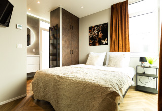 Lichte slaapkamer in Waterhoeve Wellness (Hottub) te Park Westerkogge, Nederland, met eigentijds interieur.