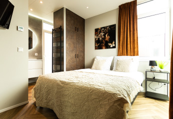 Helles Schlafzimmer in der Waterhoeve Wellness (Hottub) Lodge im Park Westerkogge, Niederlande, modern gestaltet.