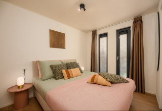 Modern bedroom at Tiny Lodge with Hot Tub, Veluwepark de Bosgraaf, Netherlands, featuring double bed.