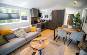 Soggiorno e cucina moderni nella Forest Lodge Comfort a Bospark Markelo, Paesi Bassi, con arredo elegante.