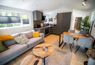 Soggiorno e cucina moderni nella Forest Lodge Comfort a Bospark Markelo, Paesi Bassi, con arredo elegante.