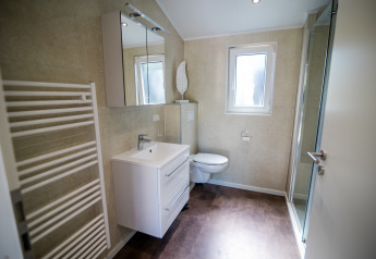 Salle de bain moderne à la Forest Lodge Comfort, Bospark Markelo, Pays-Bas, avec douche, WC et lavabo.