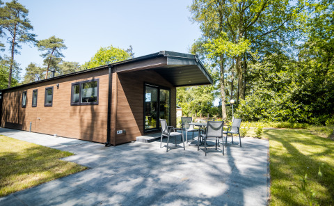 Außenaufnahme der Forest Lodge Comfort im Bospark Markelo, Niederlande, mit Terrasse und Garten.
