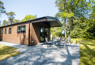Außenaufnahme der Forest Lodge Comfort im Bospark Markelo, Niederlande, mit Terrasse und Garten.
