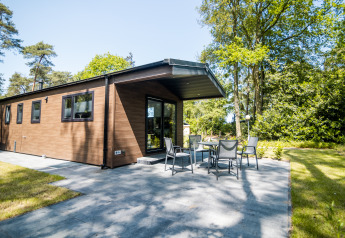 Außenaufnahme der Forest Lodge Comfort im Bospark Markelo, Niederlande, mit Terrasse und Garten.