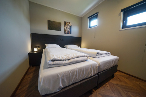 Bedroom with two single beds at Just Nature lodge in De Utrechtse Heuvelrug, Netherlands, modern style.