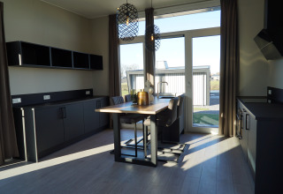 Modern kitchen and dining area at Just Nature Lodge, De Utrechtse Heuvelrug, Netherlands, with large windows.