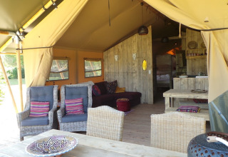 Innenansicht eines Safari-Zeltes mit gemütlicher Sitzgruppe bei Club Les Ormes in Frankreich.