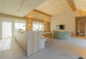 Moderne open leefruimte en keuken in Villa Lodge met Jacuzzi bij Woodz Lodges, België.