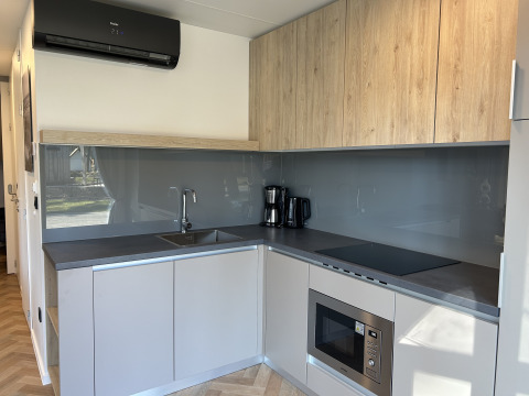 Moderne keuken in de Domus 4+2 lodge op Zilverstrand in België, met houtaccenten en apparatuur.