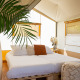 Indvendigt billede af Safari Tent Lodge med dobbeltseng, planter og hyggelig indretning i Holland.