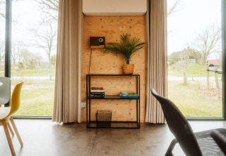 Modern lodge-interieur bij Duunroos, Holiday park De Klepperstee, met grote ramen, rek en uitzicht op de natuur.