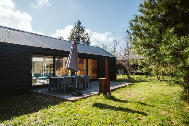Außenterrasse der t Kroaje Lodge im Holiday Park De Klepperstee in den Niederlanden mit Gartenmöbeln.