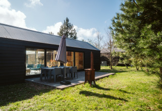 Außenterrasse der t Kroaje Lodge im Holiday Park De Klepperstee in den Niederlanden mit Gartenmöbeln.