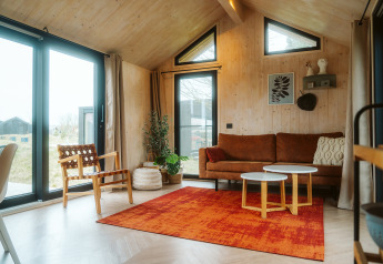 Lichte woonkamer in een tiny house bij Holiday park De Klepperstee, Nederland, met moderne meubels.