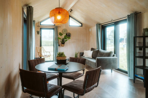 Interior luminoso y moderno de la tiny house Melle en el Holiday park De Klepperstee, Países Bajos, con comedor.