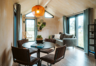 Bright, modern interior of tiny house Melle at Holiday park De Klepperstee, Netherlands, featuring a dining area.