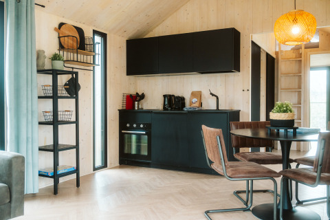 Cocina negra moderna y comedor en la tiny house Melle en Holiday park De Klepperstee, Países Bajos.