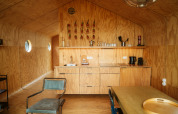 Interiør af et Wikkel tiny house i De Klepperstee, Holland, med krydsfiner vægge og minimalistisk køkken.