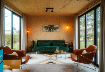 Salon moderne de la loge Kleproos, Holiday park De Klepperstee, Pays-Bas, avec grandes baies vitrées.