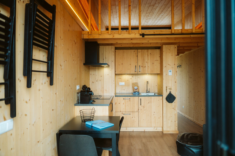 Gemütliches Tiny House aus Holz mit Küchenzeile und Essbereich im Holiday Park De Klepperstee, Niederlande.