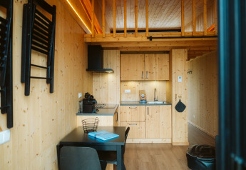 Moderne, lille træhytte med køkken, spisebord og hems på Holiday park De Klepperstee i Holland.