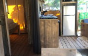 Vue intérieure de la tente safari Wood lodge au Camping Seasonova Ensoya en France, avec coin cuisine équipé.