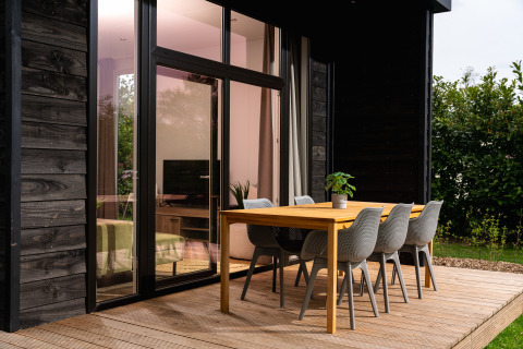 Moderner Außenessbereich an der Wellness Boutique Lodge im Holiday Park Mölke, Niederlande, bei Sonnenuntergang.