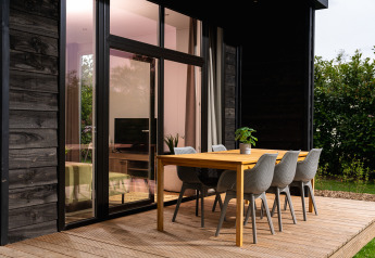 Stijlvolle buiteneettafel aan Wellness Boutique Lodge in Holiday Park Mölke, Nederland, met tuinzicht.