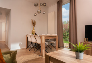 Moderne spise- og stueområde i Wellness Boutique på Holiday Park Mölke, Holland, med store vinduer.