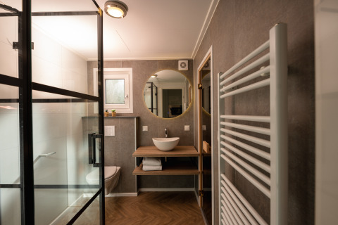 Modernes Badezimmer in der Wellness Boutique im Holiday Park Mölke, Niederlande, mit Dusche und Handtuchheizkörper.